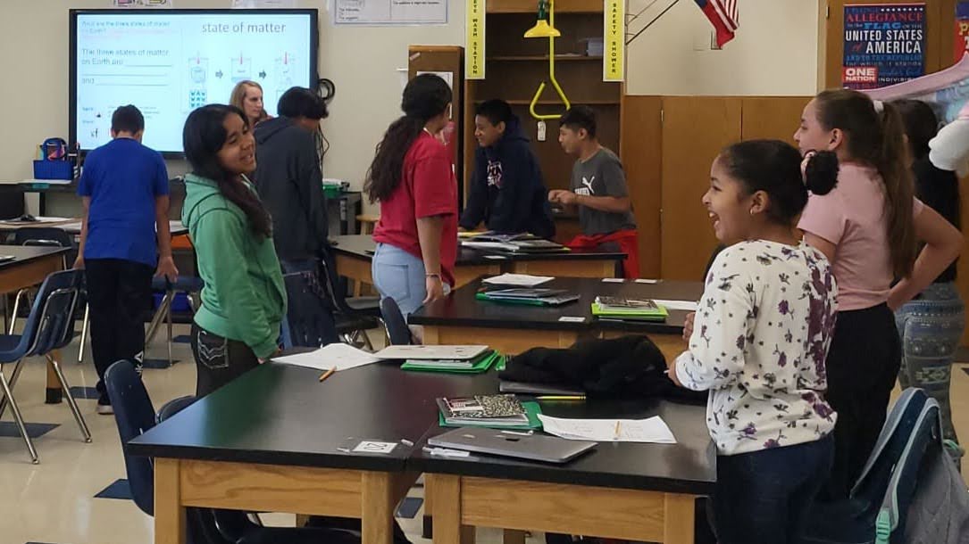 Students discussing a lesson together in their classroom.